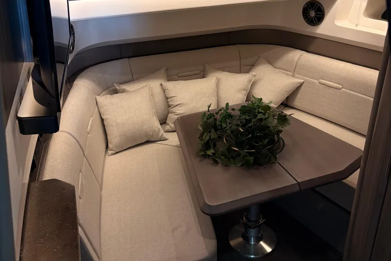 Slide: The Image of 2025 Searay 400 SLX boat interior with ambient lighting and luxurious seating. - 12