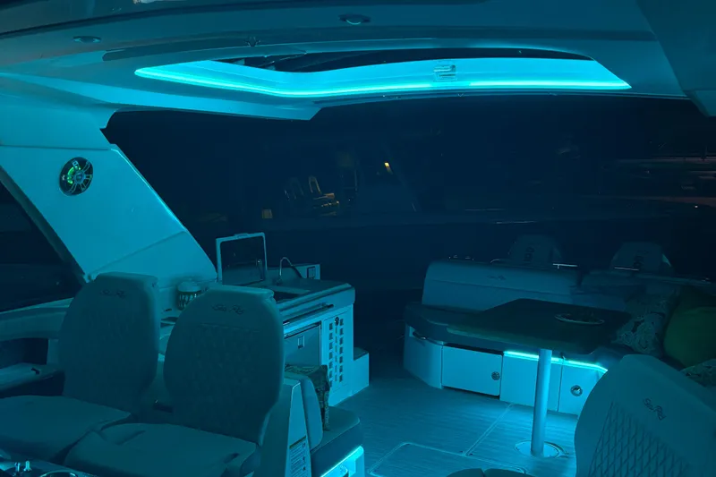 Slide: The Image of 2025 Searay 400 SLX yacht interior with ambient blue lighting and modern seating. - 7