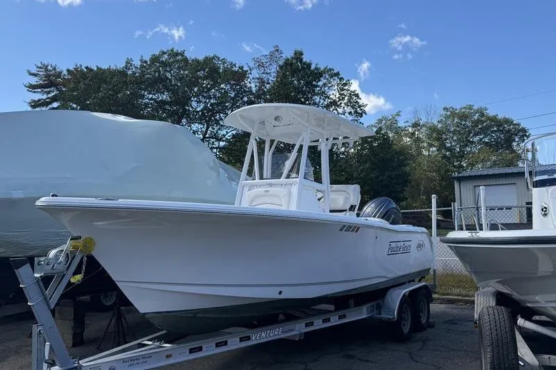 Slide: The Image of 2024 Sea Hunt Ultra 229 boat on trailer, parked outdoors under clear sky. - 0