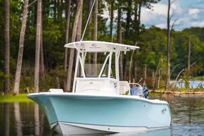 Slide: The Image of 2024 Sea Hunt Ultra 229 boat with Yamaha engine, under clear blue sky. - 1