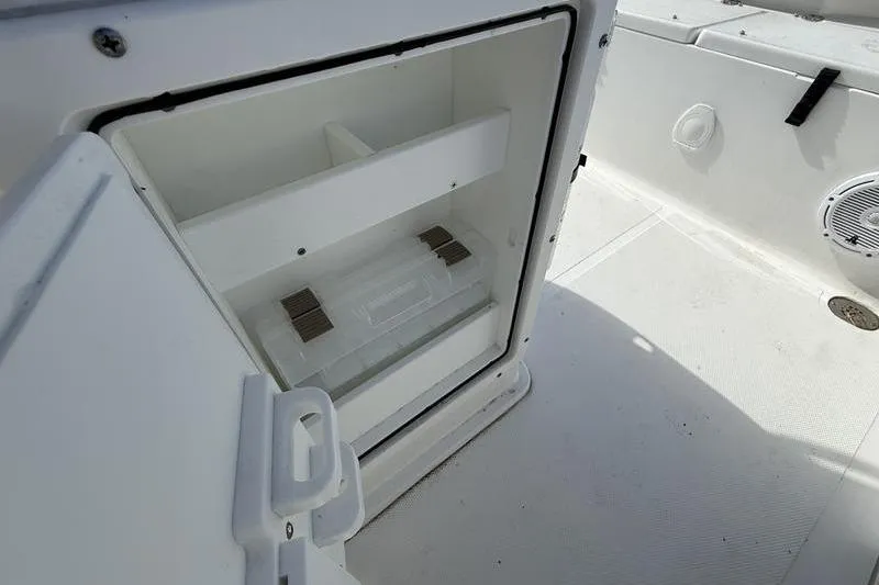 Slide: The Image of 2024 Sea Hunt Ultra 229 boat storage compartment open, showcasing interior space. - 10