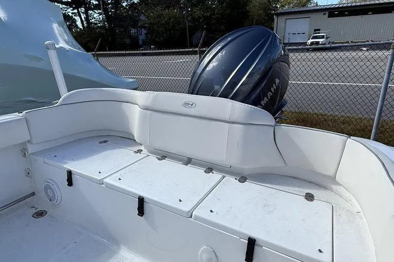 Slide: The Image of 2024 Sea Hunt Ultra 229 boat interior with Yamaha engine, featuring white seating and storage compartments. - 12