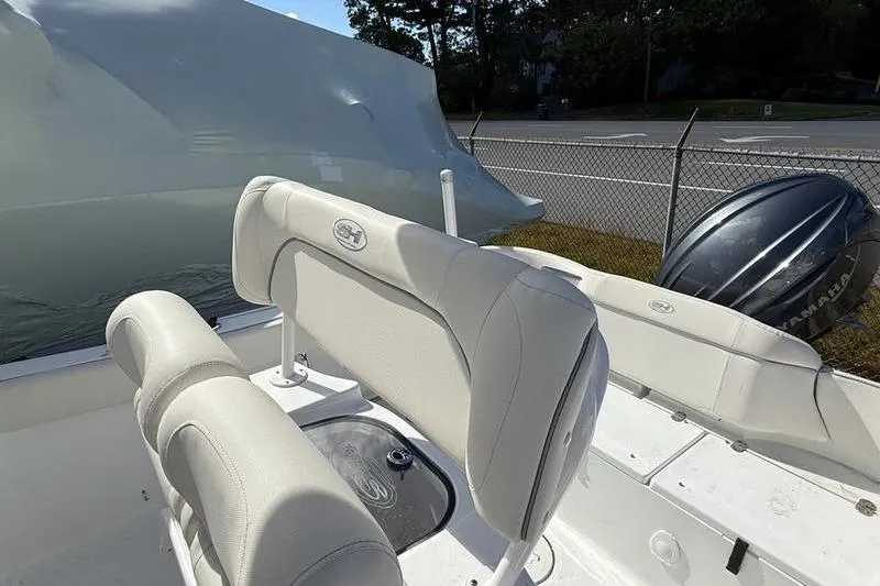 Slide: The Image of 2024 Sea Hunt Ultra 229 boat interior with cushioned seating and Yamaha outboard motor. - 2