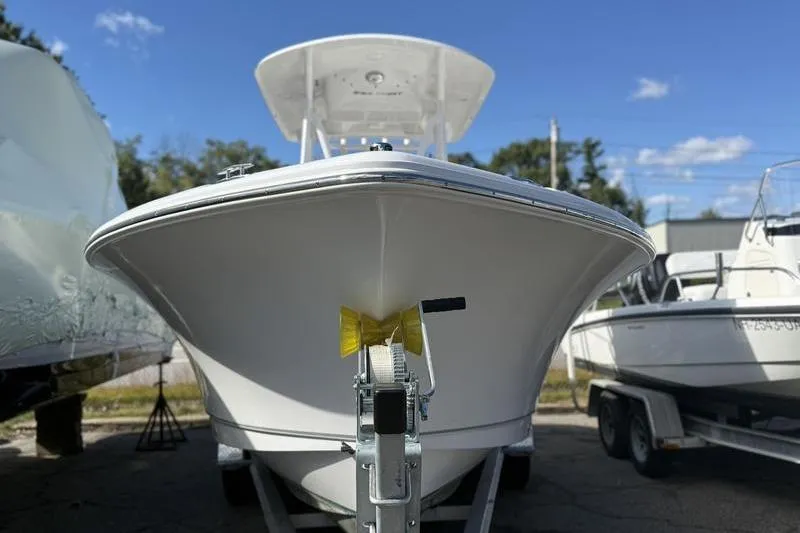 Slide: The Image of 2024 Sea Hunt Ultra 229 boat on trailer, front view under clear blue sky. - 4
