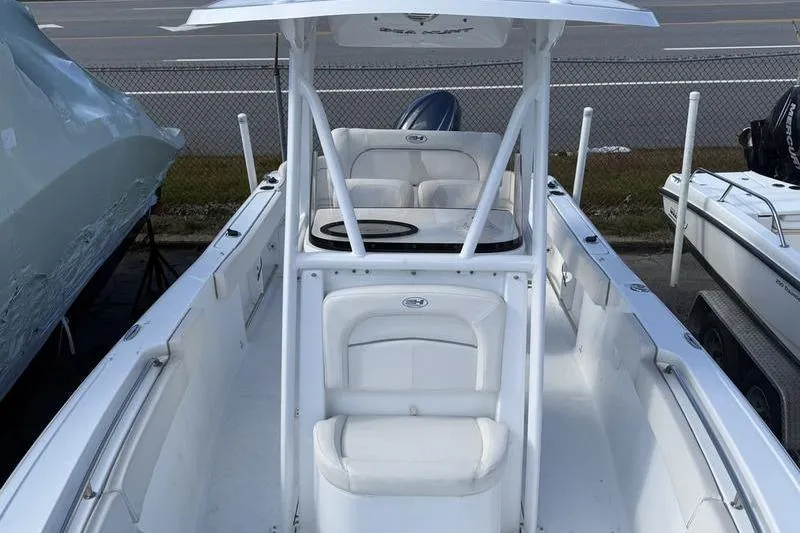 Slide: The Image of 2024 Sea Hunt Ultra 229 boat with white seating and T-top, docked outdoors. - 5