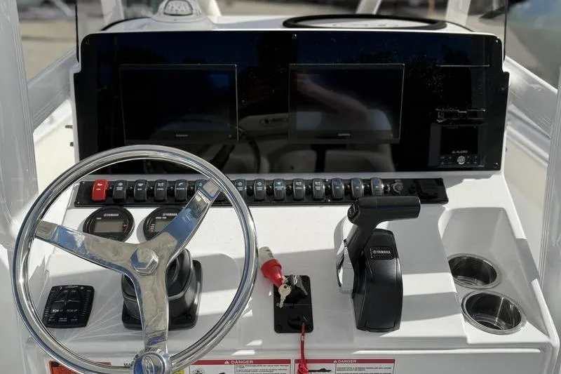 Slide: The Image of 2024 Sea Hunt Ultra 229 boat dashboard with steering wheel, controls, and display screens. - 7