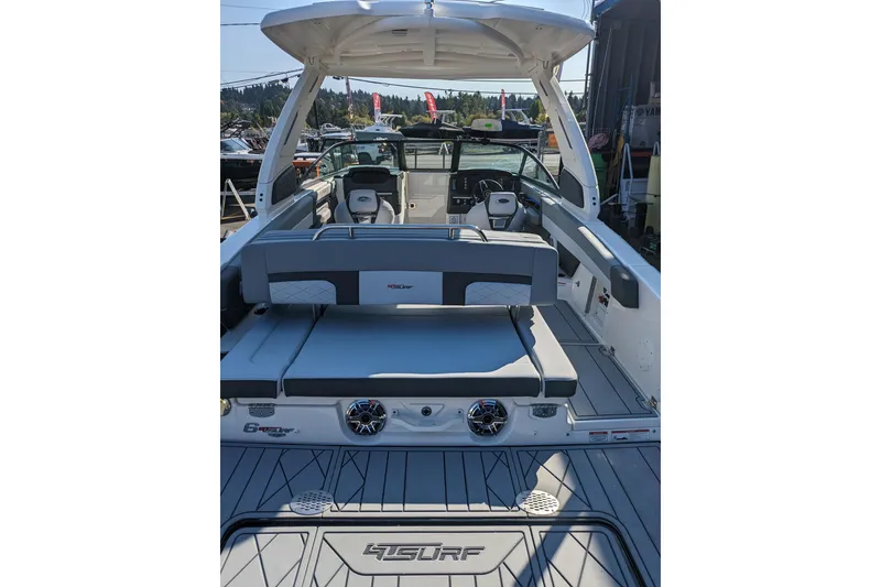 Slide: The Image of 2026 Chaparral 6 GTS boat interior with seating and dashboard, docked outdoors. - 31