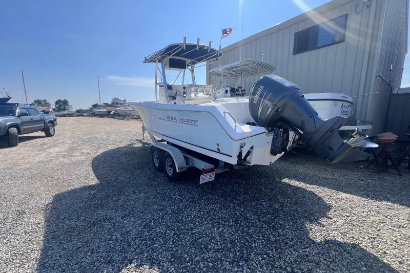 Slide: The Image of 2007 Sea Hunt Triton 240 boat on trailer, parked outdoors with Yamaha outboard motor. - 1
