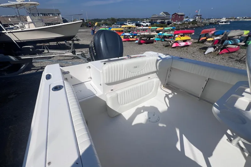 Slide: The Image of 2007 Sea Hunt Triton 240 boat interior with Yamaha engine, docked near colorful kayaks. - 12