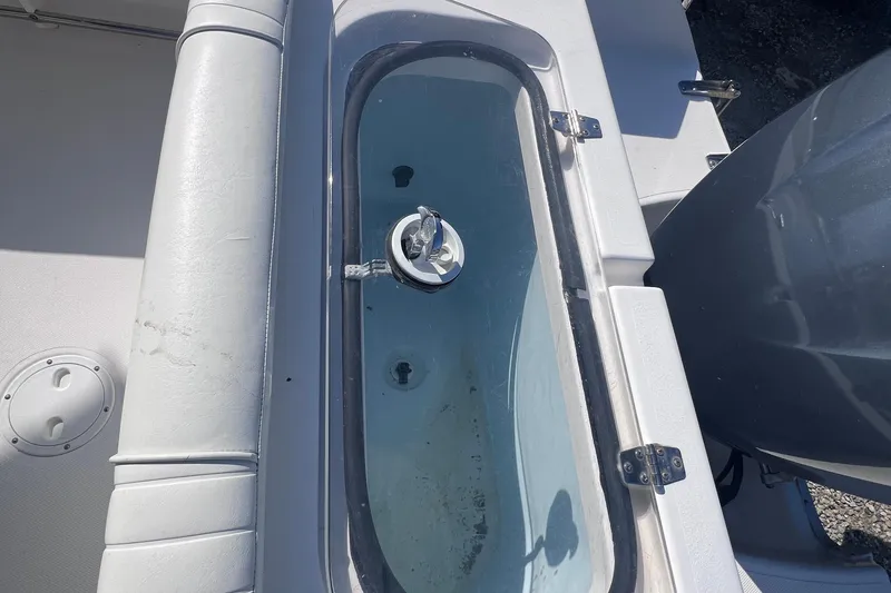 Slide: The Image of Livewell on 2007 Sea Hunt Triton 240 boat, featuring a clear lid and seating area. - 4