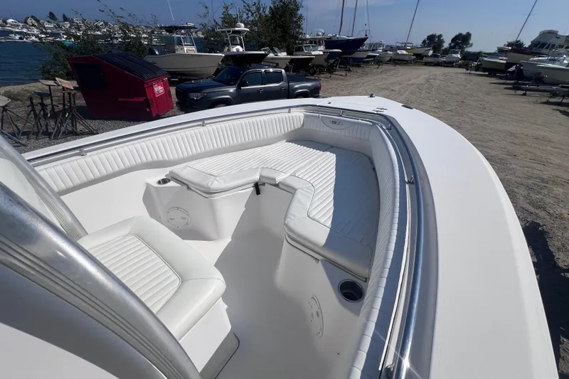 Slide: The Image of 2007 Sea Hunt Triton 240 boat with white seating, docked near a marina. - 7