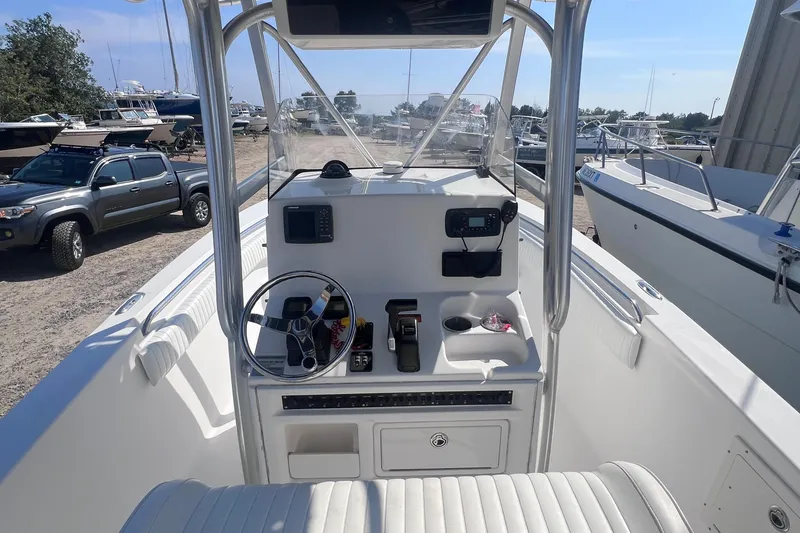 Slide: The Image of 2007 Sea Hunt Triton 240 boat console with steering wheel and controls, docked outdoors. - 8