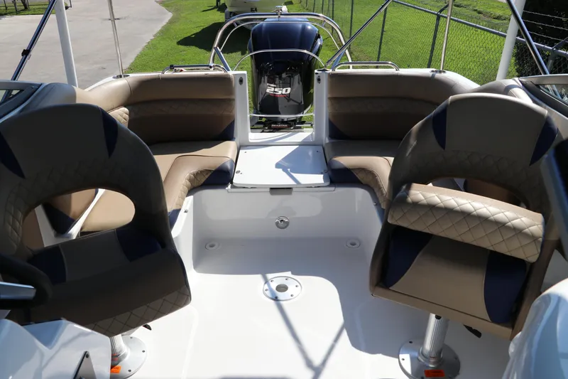Slide: The Image of 2019 Hurricane SunDeck 2486 OB boat interior with seating and outboard motor. - 12