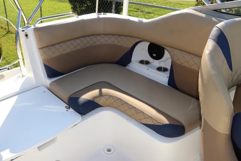 Slide: The Image of 2019 Hurricane SunDeck 2486 OB boat interior with tan and blue seating, cup holders. - 14