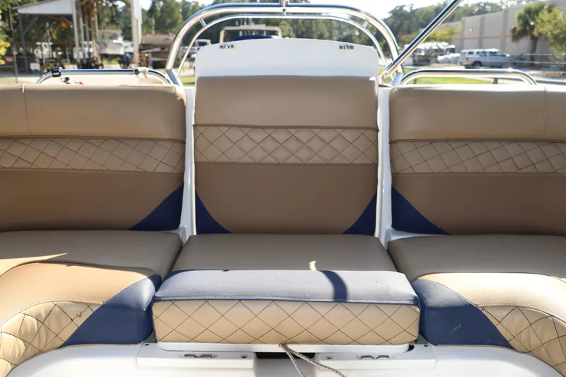 Slide: The Image of 2019 Hurricane SunDeck 2486 OB boat interior with tan and blue cushioned seating. - 15
