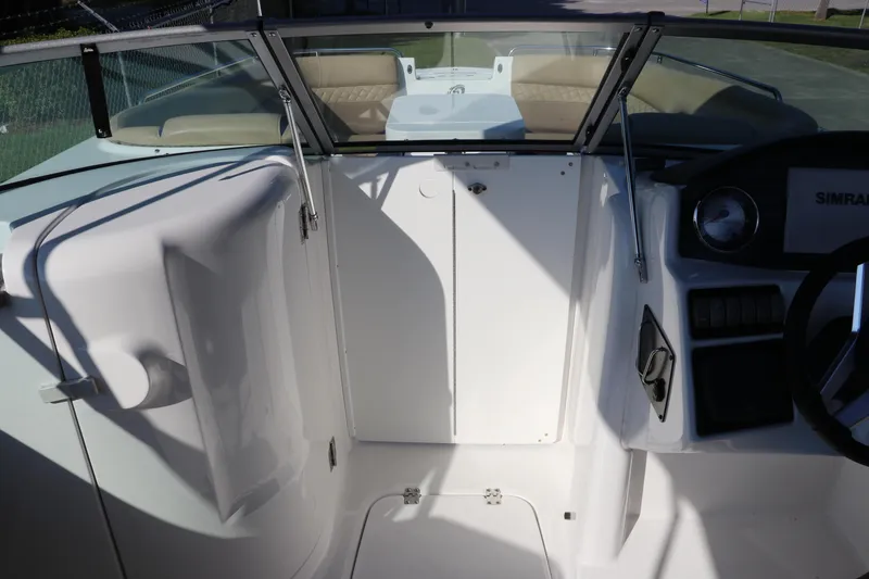 Slide: The Image of 2019 Hurricane SunDeck 2486 OB boat interior with steering wheel and seating area. - 16