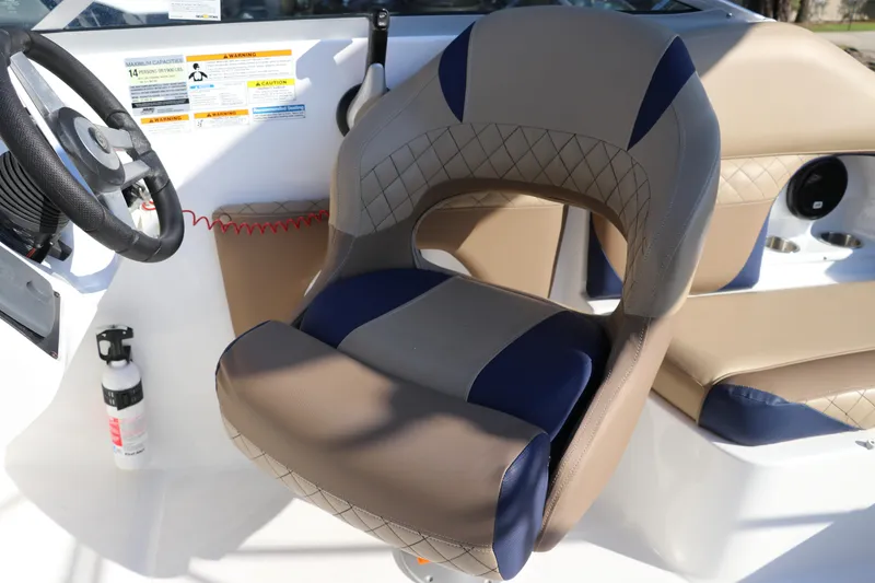 Slide: The Image of 2019 Hurricane SunDeck 2486 OB boat interior with steering wheel and cushioned seating. - 18