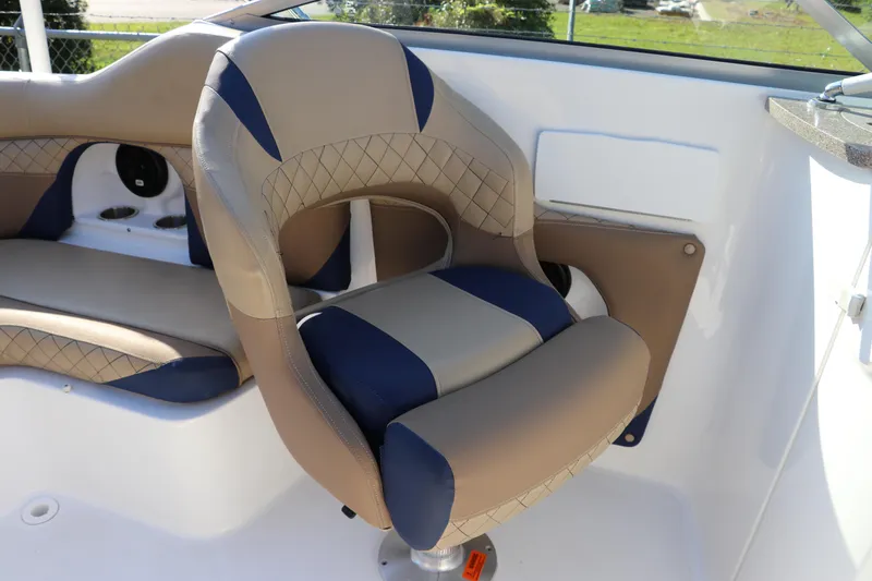 Slide: The Image of 2019 Hurricane SunDeck 2486 OB boat interior with cushioned seating and steering chair. - 20