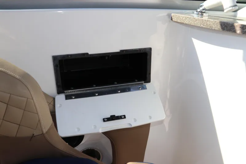 Slide: The Image of 2019 Hurricane SunDeck 2486 OB boat interior with storage compartment and beige seating. - 40