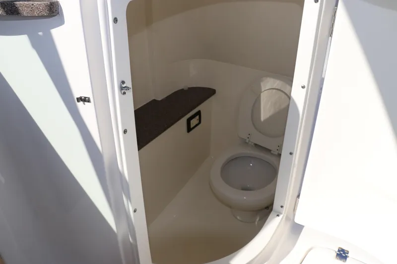 Slide: The Image of 2019 Hurricane SunDeck 2486 OB boat interior with compact marine toilet. - 43