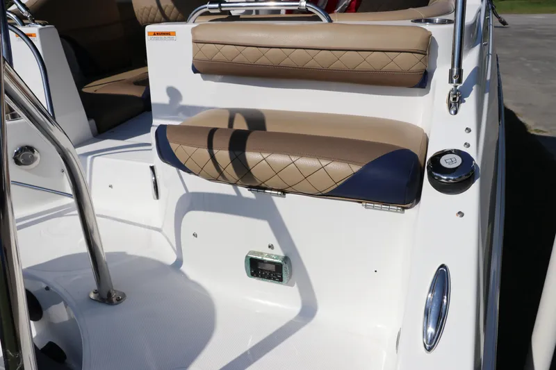 Slide: The Image of 2019 Hurricane SunDeck 2486 OB boat interior with cushioned seating and stainless steel details. - 7