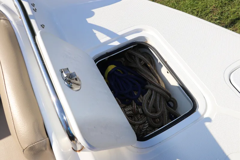Slide: The Image of Open storage compartment on 2019 Hurricane SunDeck 2486 OB boat with coiled ropes inside. - 74