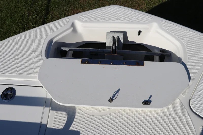 Slide: The Image of 2019 Hurricane SunDeck 2486 OB boat anchor compartment, open lid, white deck surface. - 75