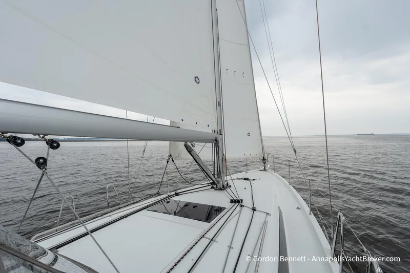 Slide: The Image of 2022 Jeanneau Sun Odyssey 410 sailing on calm waters under a cloudy sky. - 24