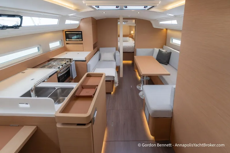 Slide: The Image of Interior of 2022 Jeanneau Sun Odyssey 410 yacht, featuring modern kitchen and seating area. - 28