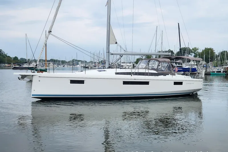 Slide: The Image of 2022 Jeanneau Sun Odyssey 410 sailboat docked in a marina, calm water reflection. - 3