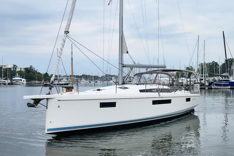 Slide: The Image of 2022 Jeanneau Sun Odyssey 410 sailboat docked in a marina, showcasing sleek design and modern features. - 4