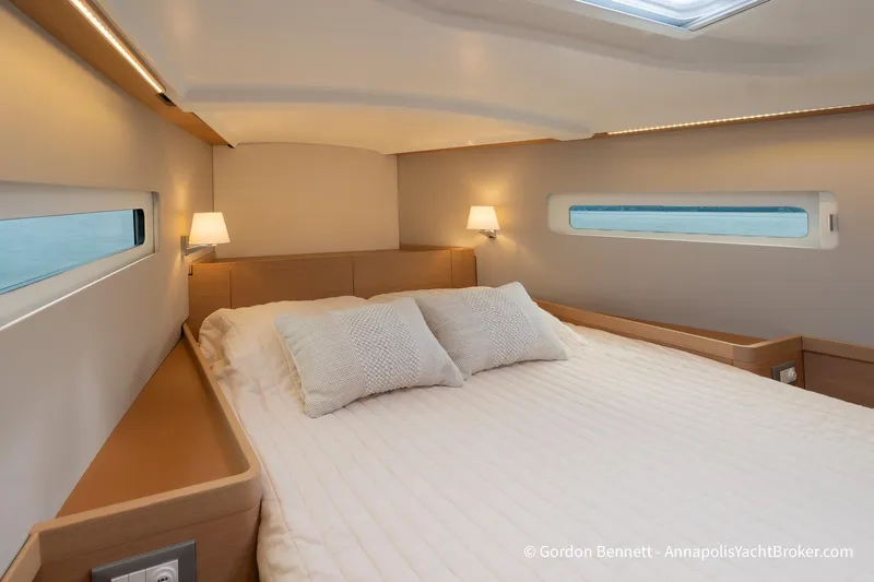 Slide: The Image of Luxurious cabin interior of 2022 Jeanneau Sun Odyssey 410 yacht, featuring cozy bedding and ambient lighting. - 51
