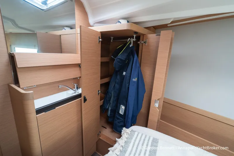 Slide: The Image of Interior of 2022 Jeanneau Sun Odyssey 410 yacht with wooden cabinetry and hanging jackets. - 53