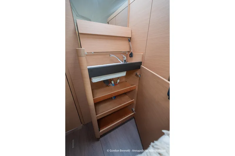 Slide: The Image of Interior of 2022 Jeanneau Sun Odyssey 410 yacht, featuring a compact wooden sink area. - 55