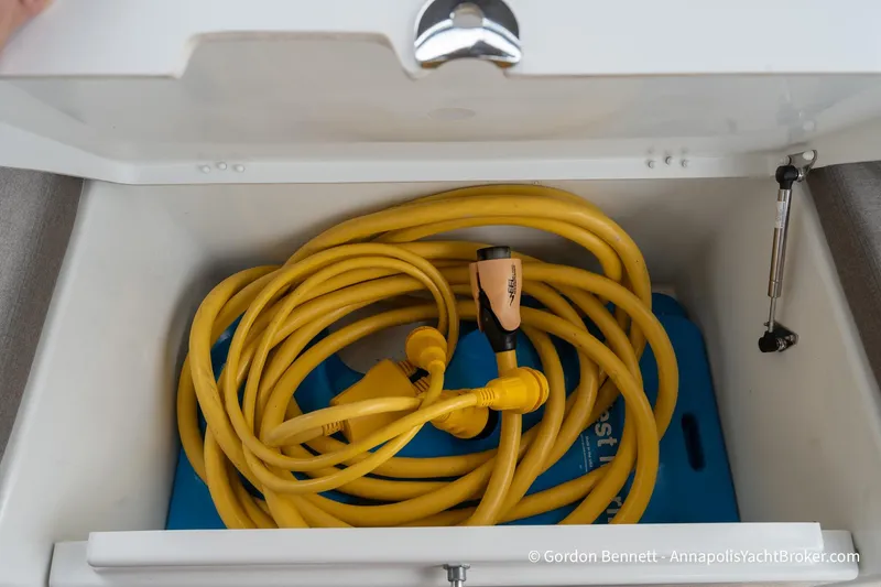 Slide: The Image of Yellow power cable stored in Jeanneau Sun Odyssey 410 yacht compartment, 2022 model. - 65