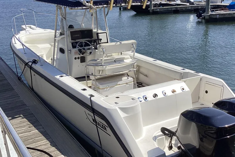 The Image of 2001 Boston Whaler 260 Outrage boat docked at marina, featuring dual engines. - 0