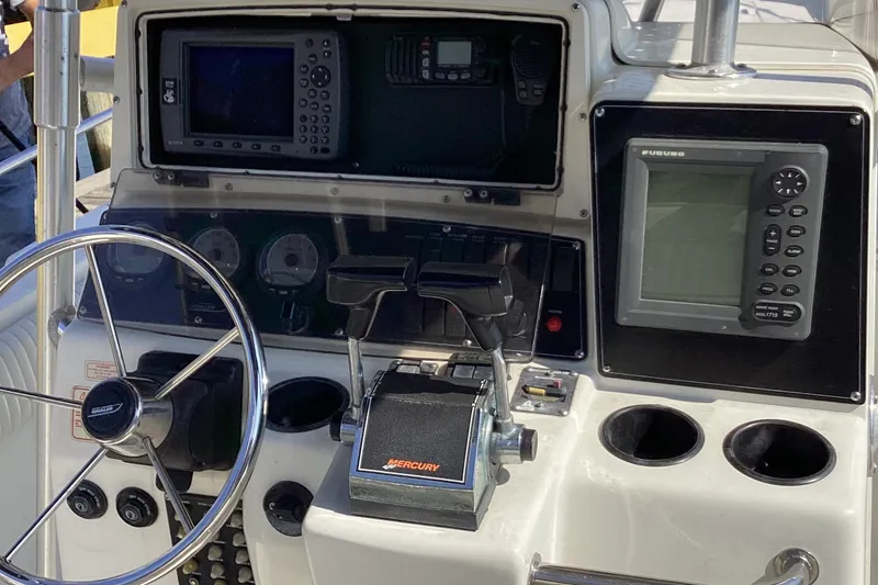 Slide: The Image of 2001 Boston Whaler 260 Outrage dashboard with steering wheel and navigation equipment. - 13