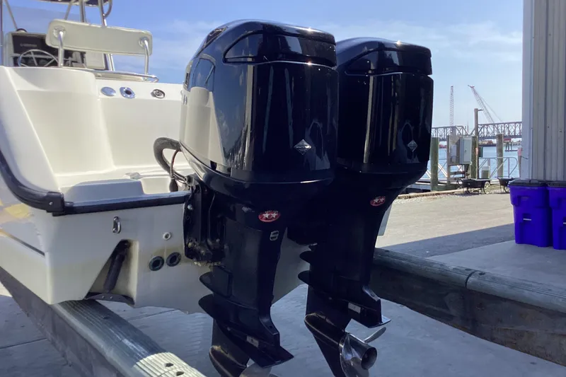 Slide: The Image of 2001 Boston Whaler 260 Outrage with dual outboard engines at a dockside location. - 2