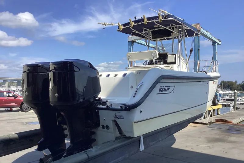Slide: The Image of 2001 Boston Whaler 260 Outrage boat with dual engines on a dock. - 3
