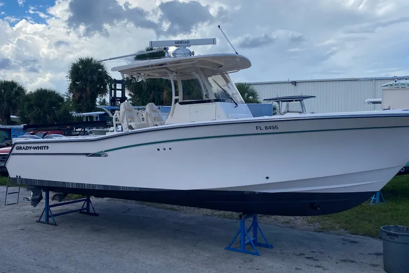 The Image of 2018 Grady-White Canyon 306 boat on stands, outdoor setting, cloudy sky. - 0