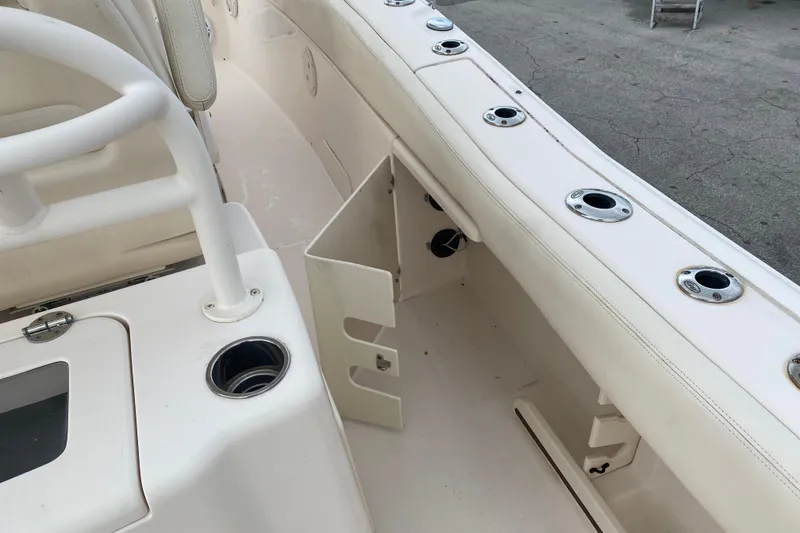 Slide: The Image of 2018 Grady-White Canyon 306 boat interior with rod holders and storage compartment. - 11