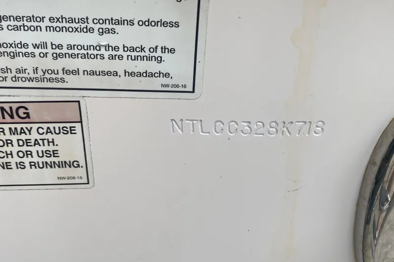 Slide: The Image of 2018 Grady-White Canyon 306 boat with safety warning labels and hull identification number. - 20