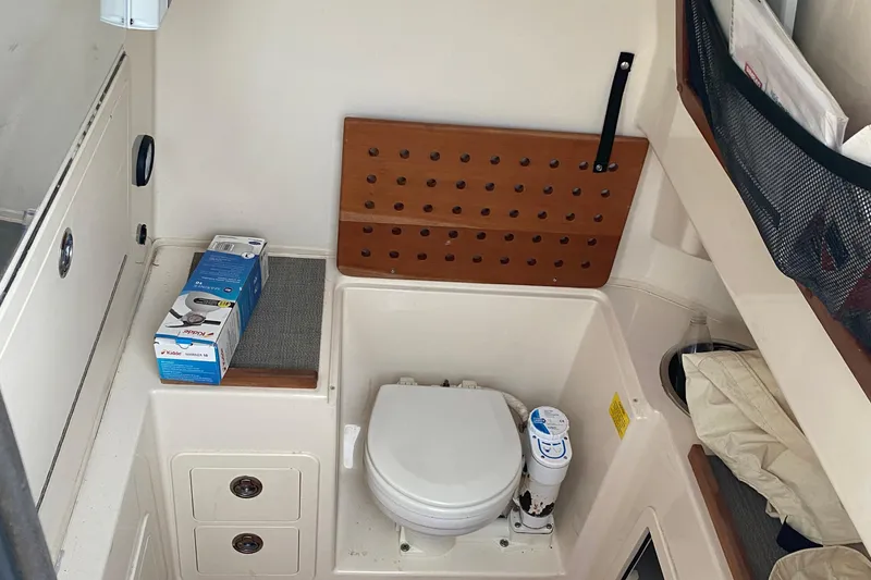 Slide: The Image of 2018 Grady-White Canyon 306 boat interior with compact marine toilet and storage. - 6