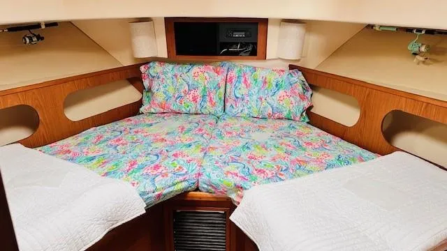 Slide: The Image of 1999 Mainship 430 Trawler bedroom with cozy bed, TV, and wooden accents. - 13