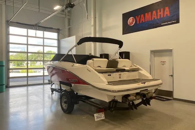 Slide: The Image of 2015 Scarab 215 boat interior with seating and deck, displayed in showroom. - 12