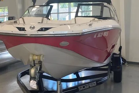 Slide: The Image of 2015 Scarab 215 boat interior in showroom, featuring beige seating and modern design. - 13