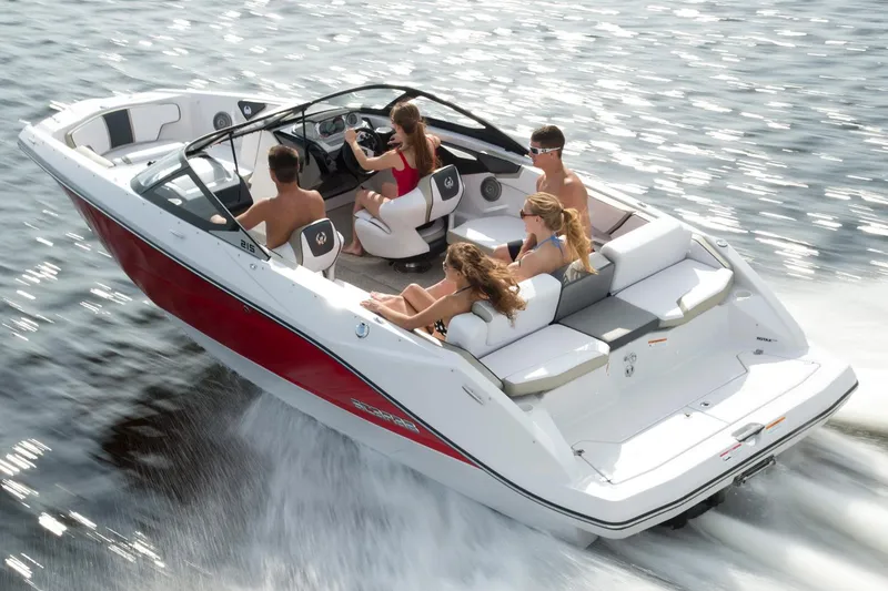 Slide: The Image of 2015 Scarab 215 boat with red hull on trailer, parked outside Munson dealership. - 2