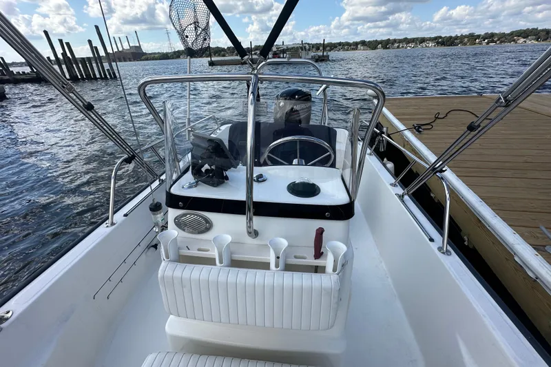 Slide: The Image of 2016 Boston Whaler 170 Montauk boat interior with steering wheel, docked by the water. - 5