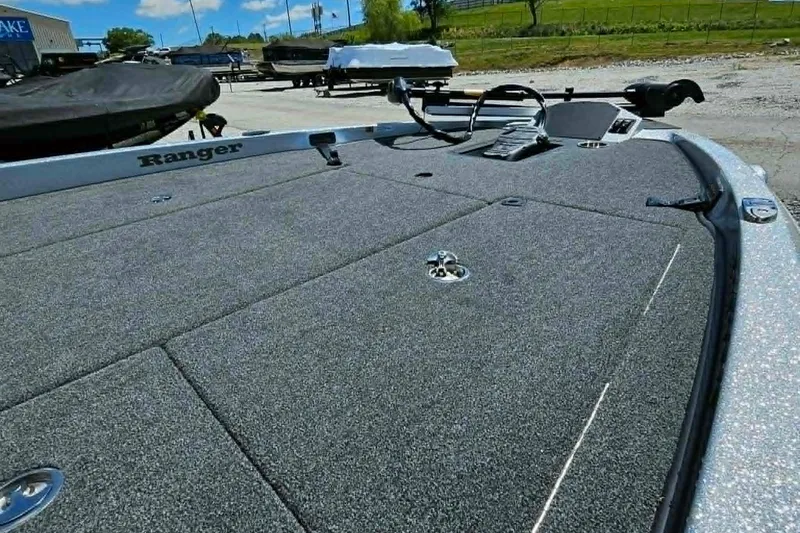 Slide: The Image of 2025 Ranger Z185 boat deck with carpeted surface and storage compartments. - 13