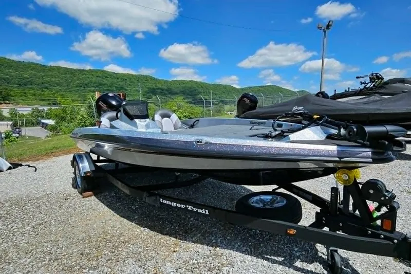 Slide: The Image of 2025 Ranger Z185 boat on trailer, parked outdoors under blue sky. - 14